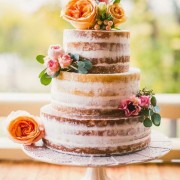 Tendencias en pasteles de bodas para este año: ¡Vivan las tartas semi-desnudas! Pastel rústico cubierto con una capa fina de crema de mantequilla, adornado con rosas frescas de distintos colores que se complementan.