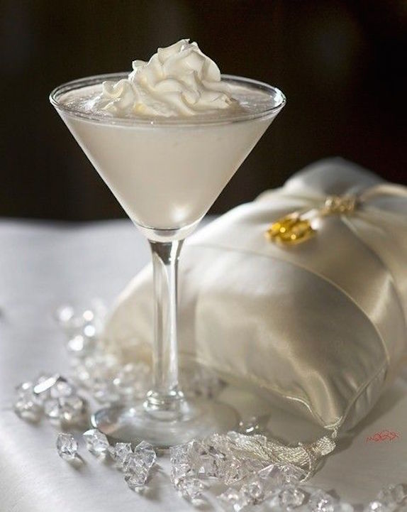 Receta de cocteles para bodas. Wedding Cake Martini hecho con 1,5 onzas de vodka de vainilla 1/2 oz de ron de coco Malibú 1,5 oz de jugo de piña 1 chorrito jarabe de granadina. Cocktail recipe for a Wedding Cake Martini made with 1.5 oz vanilla vodka 1/2 oz Malibu coconut rum 1.5 oz pineapple juice 1 splash grenadine syrup.