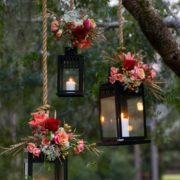 Faroles para bodas colgantes con flores en rosa para la decoración de tu recepción. Fotografía: Hopkins Studios.