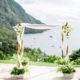 Un arco de flores para bodas con bambu con tela entrelazada y arreglos de flores blancas creado por Jardin Tropical. Toma nota del paso a paso!