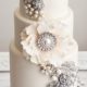 A white cake with pearls, crystals and jewelry is a perfect fit for a glam wedding. Created by De La Creme Creative Studio.