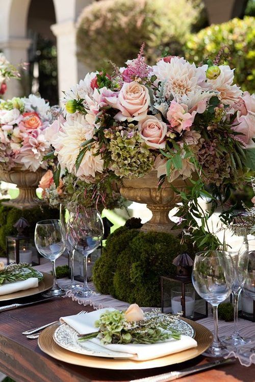 Floral centerpiece with a moss base for a garden wedding.