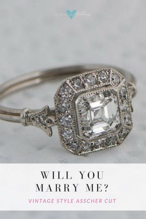 Beautiful vintage style Asscher diamond ring. It is surrounded by sixteen brilliant diamonds. A fleur-de-lis design and triple wire shank add to the delicacy of this ring. The ring has a GIA certification.