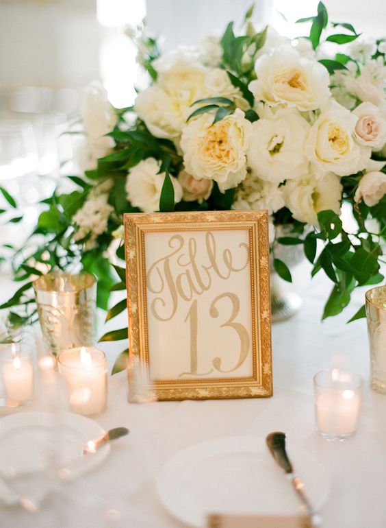 Wedding table ideas on a budget. Achieve the classic-clam look with a golden frame some votives and a delicate flower arrangement in white and green like at this stunning West Hollywood wedding. Photography: Jose Villa Photography.