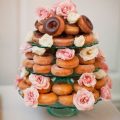 A three tiered glass cake stand combined with a garnish of white and pink roses transform this plain doughnuts stack into something spectacular. Photo: MegRuth Photo.