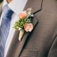 Para una boda elegante y campestre en el otoño, este boutonniere se luce con suculentas y acentos con flores en coral.