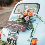 Vintage getaway car that is all kinds of chic adorned with florals and calligraphy.