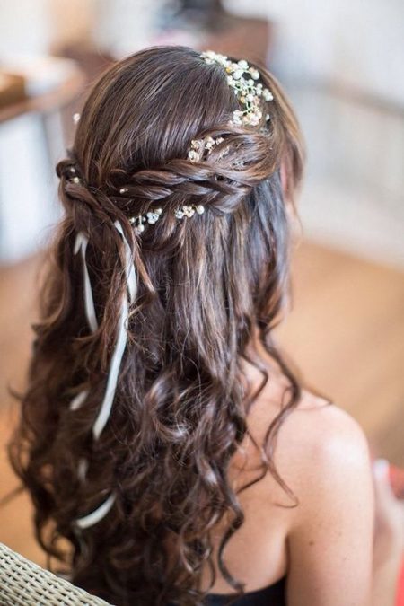 Pelo suelto con trenza y una corona de baby's breath.