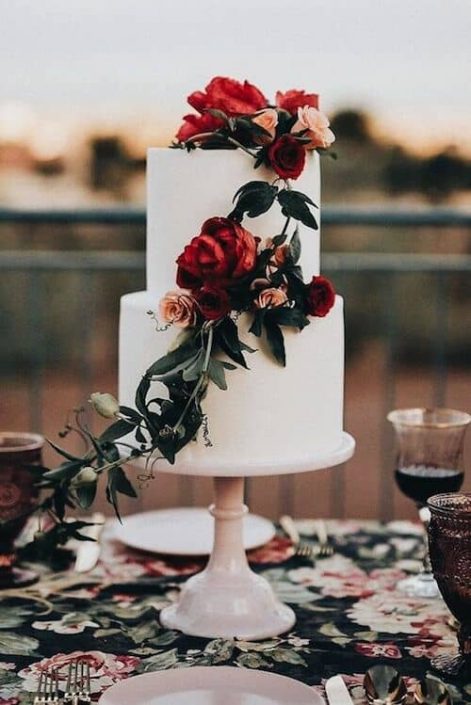 Love the contrast of the moody color palette against the white wedding cake! Photo: Jonnie and Garrett.