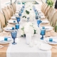 Una mesa de banquete de bodas al aire libre en beige, blanco y azul. Detalle de porta servilletas al tono. Valorie Darling Photography.