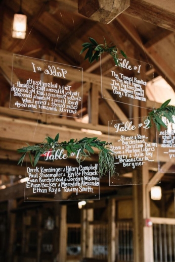 Amazing and original hanging acrylic seating charts with greenery.